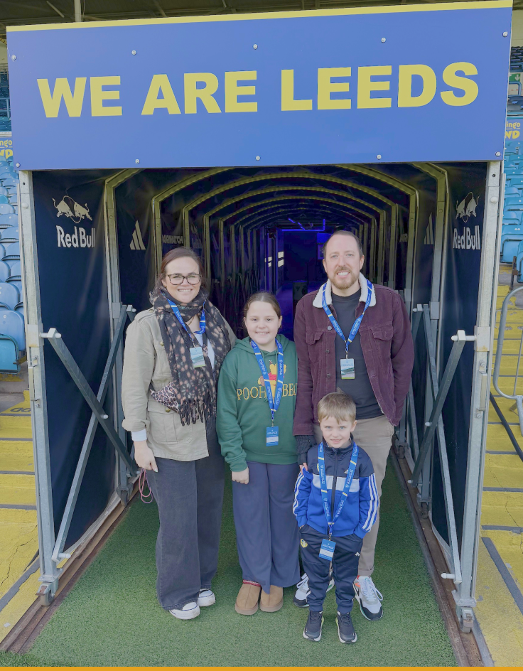 Mikey standing with his family outside Elland Road