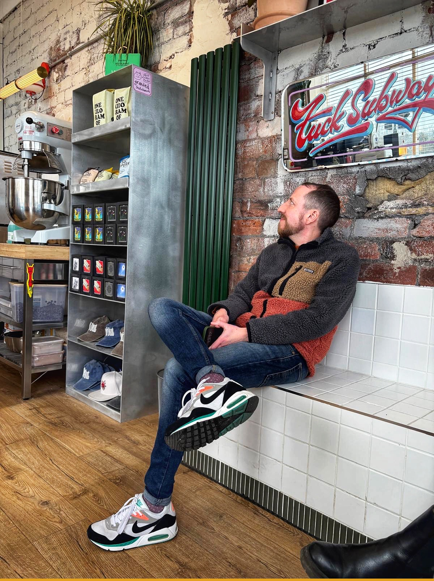 Mikey sitting in a sandwich shop looking towards the window